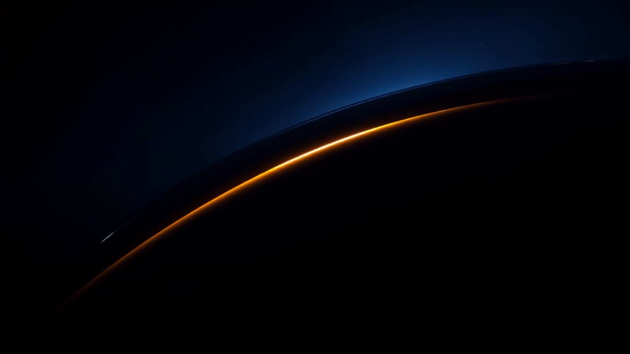 An amber highlight tracing the curve of a dark car body panel