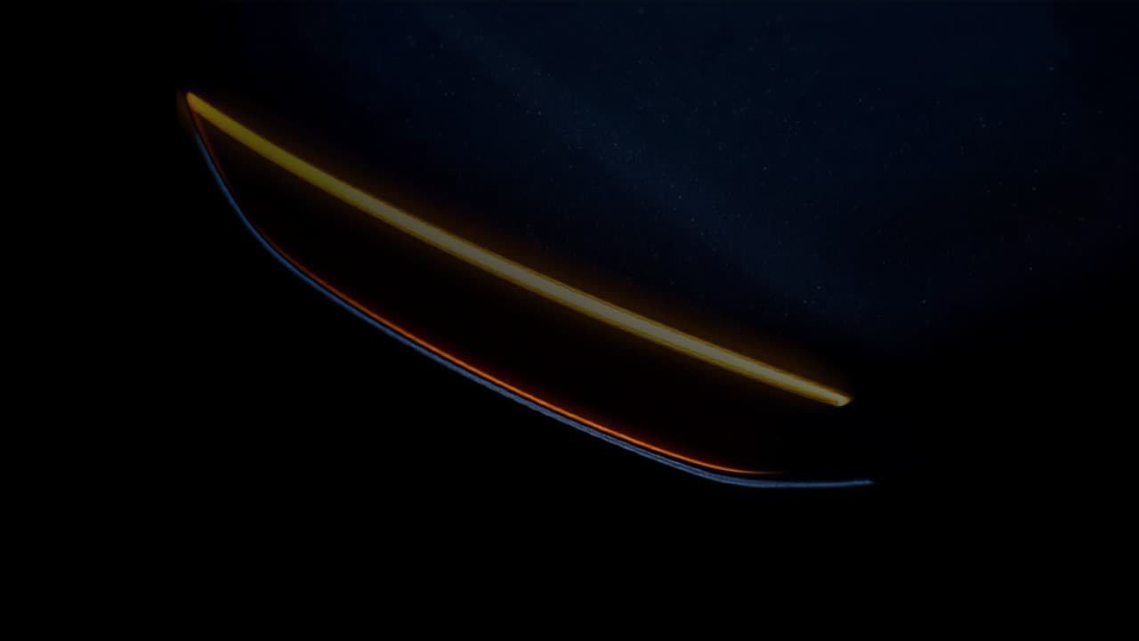 A close detail of a car headlight edge catching amber light
