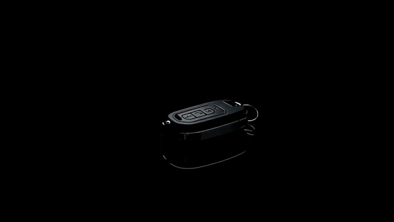 A modern car key fob almost lost in deep shadow