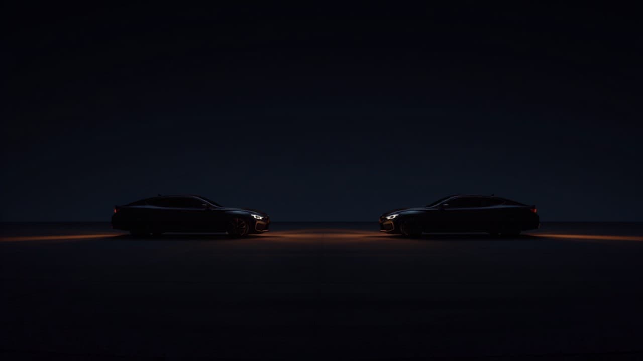 Two cars parked side by side in a dark empty lot at night