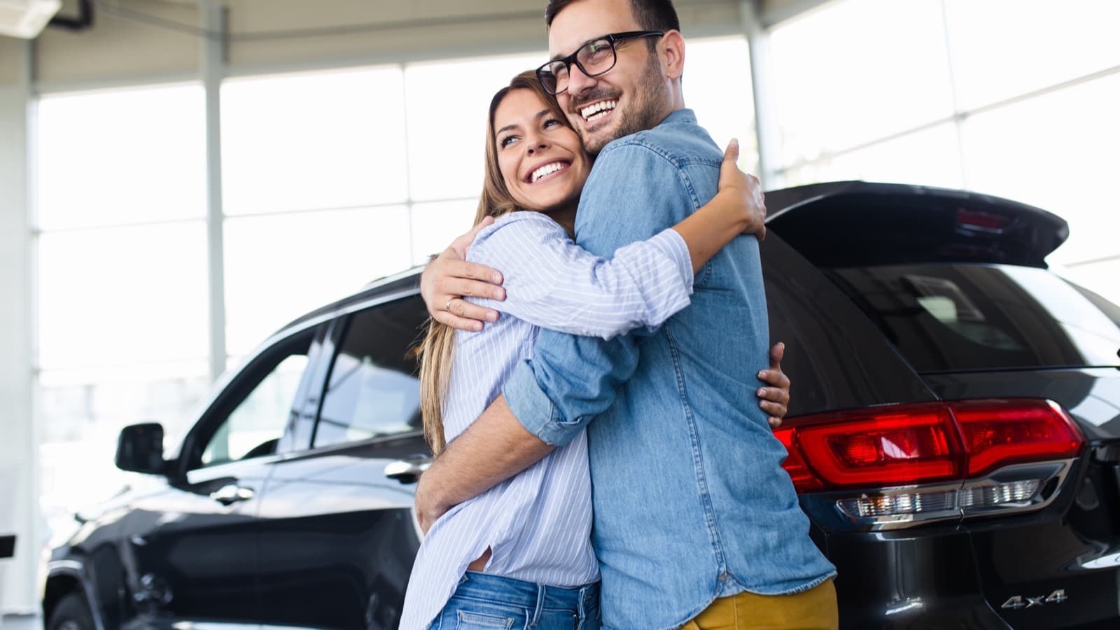 A couple choosing a new car in a showroom