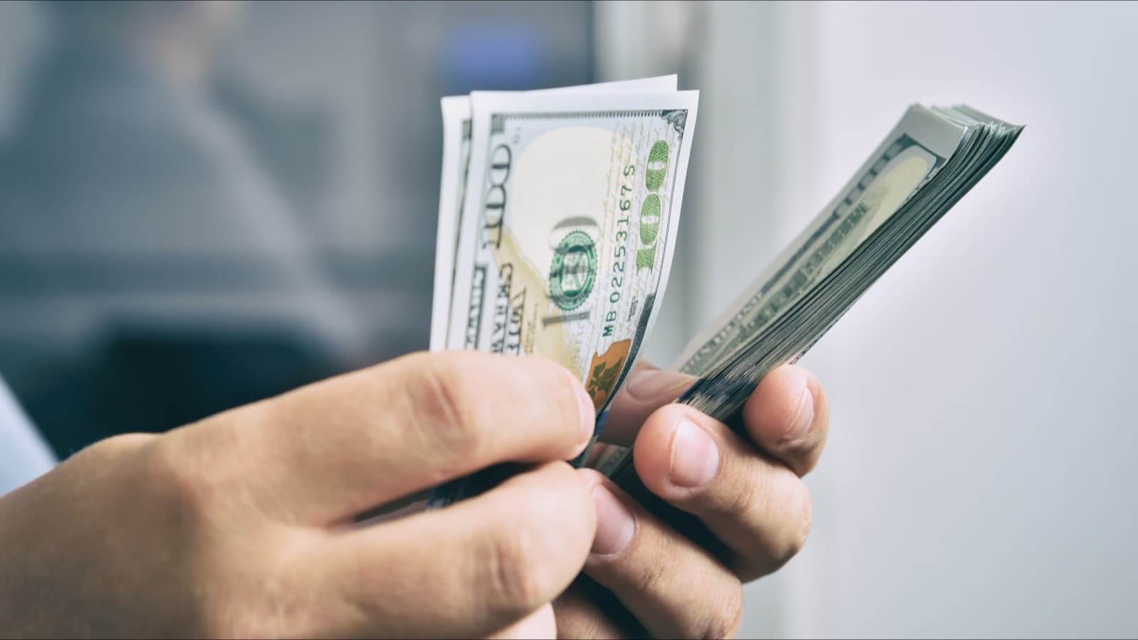 Hands counting hundred dollar bills