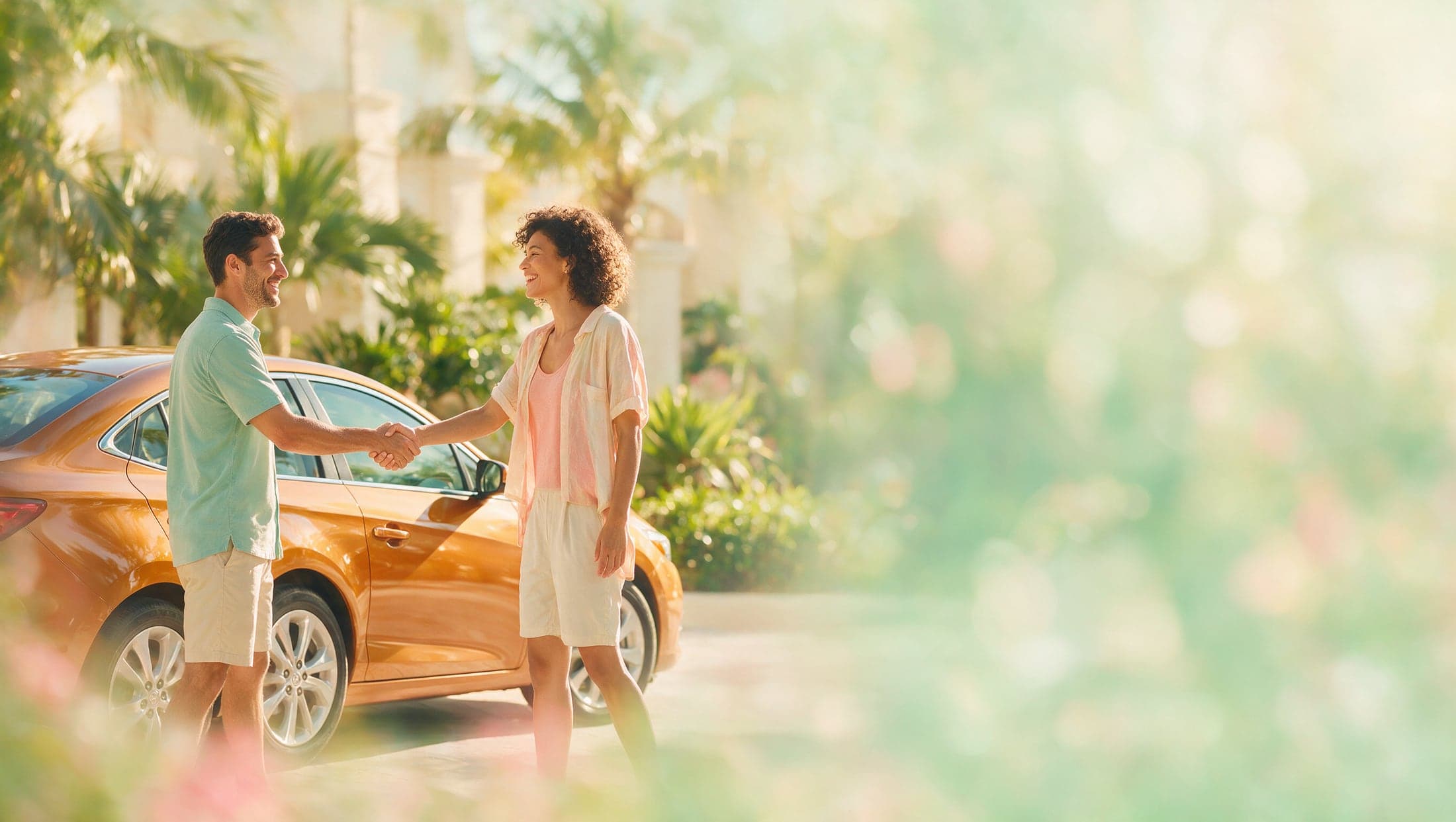 Two people shaking hands over a completed car deal