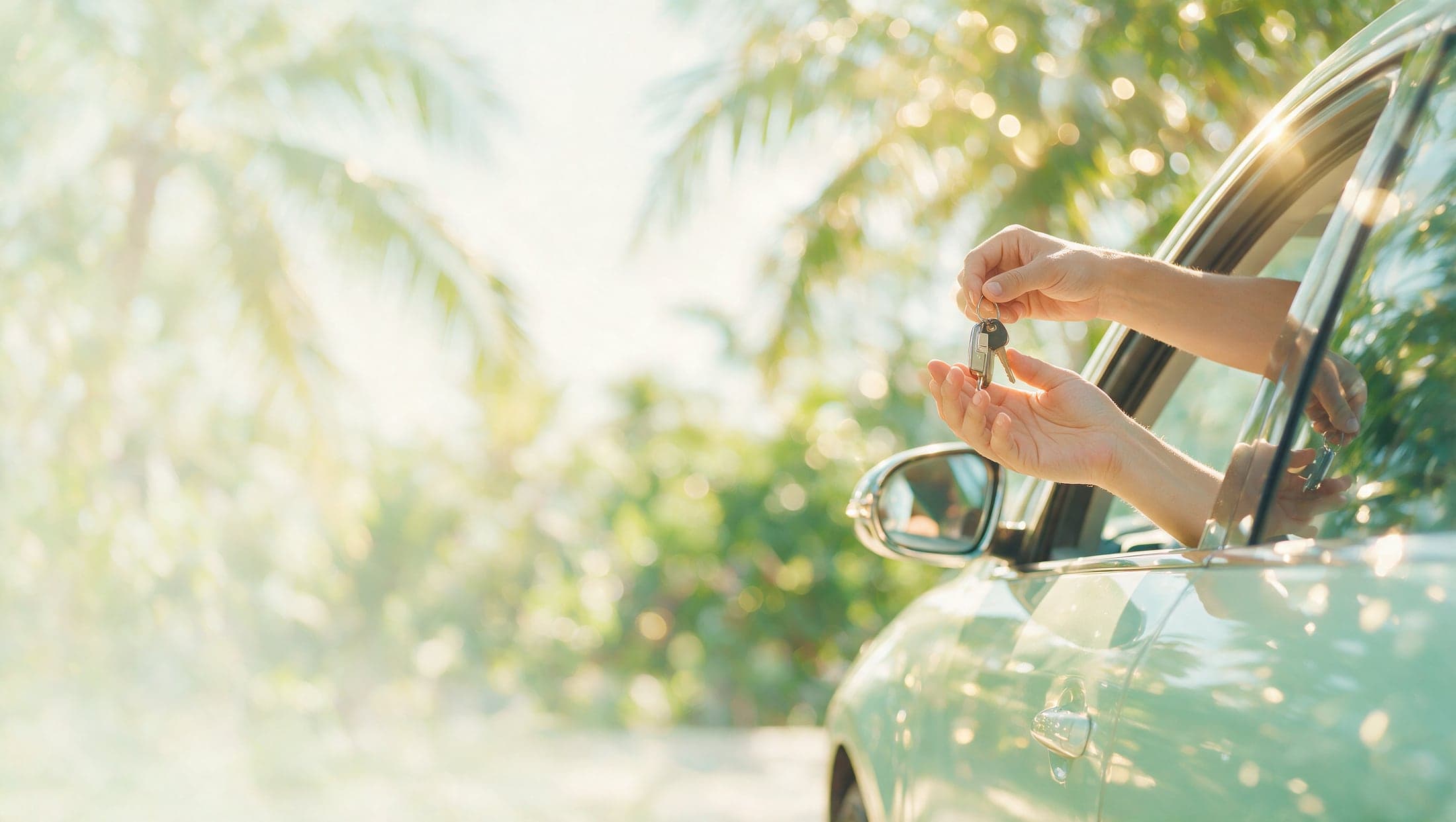 A set of car keys being handed across
